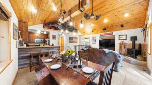 une cuisine et une salle à manger avec une table en bois dans l'établissement Outdoor Dining Fireplace Trails Nearby Cedar Hollow Retreat by AvantStay, à Pomins