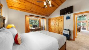 une chambre avec un grand lit blanc et un bureau dans l'établissement Outdoor Dining Fireplace Trails Nearby Cedar Hollow Retreat by AvantStay, à Pomins