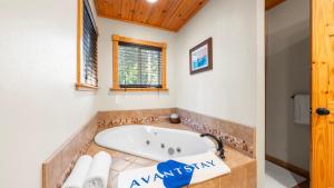 La salle de bains est pourvue d'une baignoire et d'un plafond en bois. dans l'établissement Outdoor Dining Fireplace Trails Nearby Cedar Hollow Retreat by AvantStay, à Pomins 31 autres photos