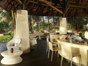 un restaurante con muebles blancos, mesas y sillas en SO/ Sofitel Mauritius, en Bel Ombre