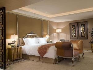 a bedroom with a large bed and a chair at Sofitel Harbin in Harbin
