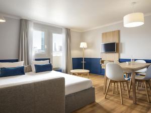 a hotel room with a bed and a dining room at Aparthotel Adagio La Défense Kléber in Courbevoie