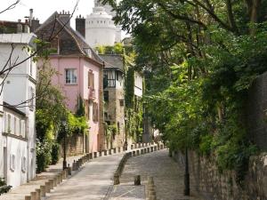 an empty street in a town with pink buildings at Aparthotel Adagio Paris Montmartre in Paris
