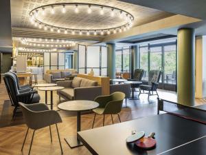 伊西莱穆利诺凡尔赛宫阿德吉奥公寓酒店的酒店大堂设有桌椅和吊灯。