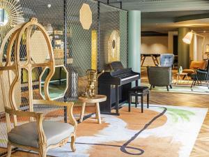 a store with chairs and a piano in a room at Aparthotel Adagio Porte de Versailles in Issy-les-Moulineaux