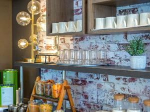 a shelf with cups and other items on it at ibis Lyon Sud Vienne Saint-Louis in Vienne