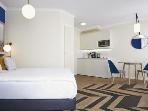 a bedroom with a bed and a table and chairs at Aparthotel Adagio Porte de Versailles in Issy-les-Moulineaux +67 photos