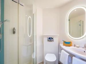 a bathroom with a shower and a toilet and a sink at ibis Lyon Sud Vienne Saint-Louis in Vienne +102 photos
