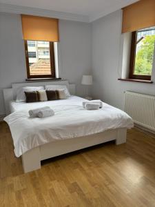 Un dormitorio con una gran cama blanca con dos toallas encima. en Teo Apartment, en Pristina