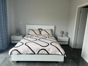a bedroom with a bed with a black and white comforter at Villa Bacana Oasis in Estreito da Calheta
