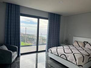 a bedroom with a bed and a large window at Villa Bacana Oasis in Estreito da Calheta
