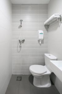 a white bathroom with a toilet and a shower at Value Hotel Nice in Singapore