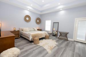 Un dormitorio con una cama, una mesa y un espejo. en The Blue House, en Hitchcock