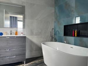 a bathroom with a white tub and a sink at Villa Bacana Oasis in Estreito da Calheta +37 photos