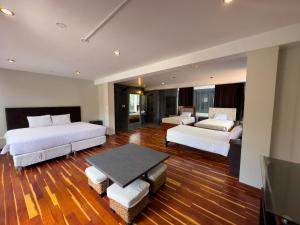 a large room with two beds and a table at Hotel California Urubamba in Urubamba