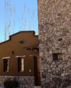 un edificio con una pared de piedra junto a una puerta en Juella cabaña, en Tilcara