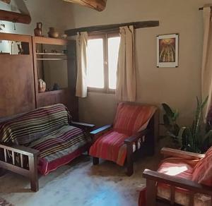 Habitación con cama, silla y ventana en Juella cabaña, en Tilcara
