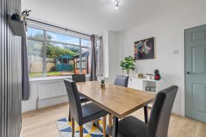 a dining room with a wooden table and chairs at #69 Stylish and comfy home in CV3 in Parkside