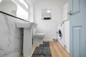 a bathroom with a sink and a washing machine at #69 Stylish and comfy home in CV3 in Parkside +35 photos