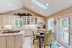 a kitchen with white cabinets and a table and chairs at Betsie Woods in Thompsonville