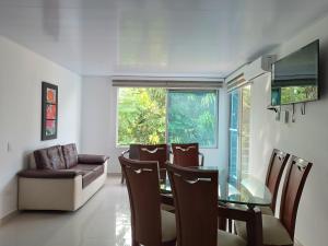 a dining room with a glass table and chairs at centrico Apartamento con piscina Anapoima in Anapoima +10 photos