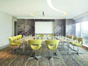 a conference room with a long table and yellow chairs at Novotel Tangerang in Tangerang +61 photos