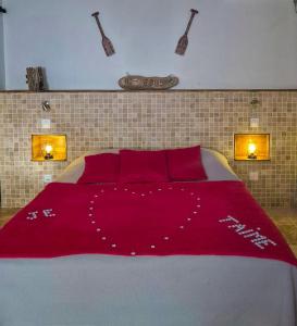 a bedroom with a large bed with a red blanket at Chez didine in Terre-de-Haut