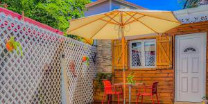 豪特尔Chez didine的露台上遮阳伞下的桌子和椅子