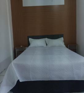 a large bed with white sheets and pillows at Quarto confortável COP30 in Belém