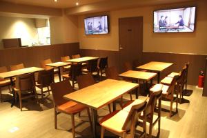 a restaurant with tables and chairs and televisions on the wall at Gran Custama Ueno in Tokyo