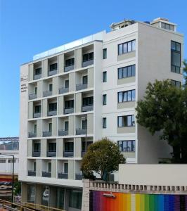 a white building with a rainbow fence in front of it at Hotel Infante Santo - Lisboa in Lisbon