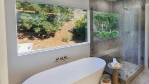 a bathroom with a tub and a large window at Spanish-Inspired Mission Viejo Home with Courtyard Firepit Backyard Dining Casa Cordero by AvantStay in Galivan +35 photos