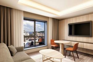 a living room with a couch and a table and a window at Delta Hotels by Marriott Istanbul Karakoy in Istanbul