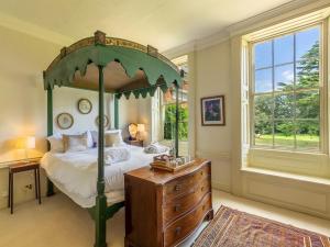 a bedroom with a canopy bed and a wooden dresser at 9 Bed in Ingoldisthorpe KT095 in Ingoldisthorpe +45 photos