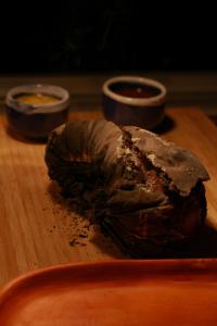 a piece of meat on a wooden table with dipping sauces at Hotel Casa Selvaggio in Ráquira