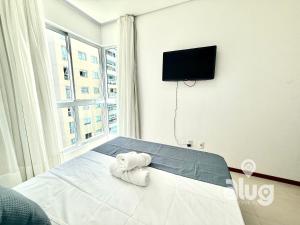 a room with a bed with a tv and a window at Pé na Areia Vista Mar Beto Carrero e Férias in Piçarras +57 photos