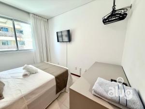 a bedroom with two beds and a tv on the wall at Pé na Areia Vista Mar Beto Carrero e Férias in Piçarras +83 photos