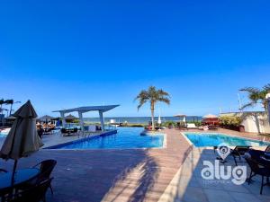a swimming pool with a view of the ocean at Pé na Areia Vista Mar Beto Carrero e Férias in Piçarras