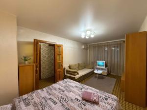 a bedroom with a bed and a couch and a television at Суворова-Титова in Dnipro +2 photos
