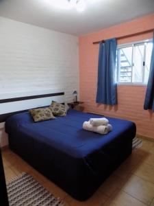 Un dormitorio con una cama con sábanas azules y una ventana. en HoltFor, en Potrero de los Funes 49 fotos más