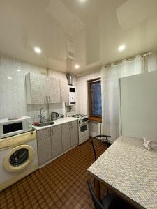 a kitchen with a washing machine and a table with a counter at Суворова-Титова in Dnipro