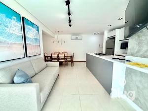 a living room with a couch and a kitchen at Pé na Areia Vista Mar Beto Carrero e Férias in Piçarras