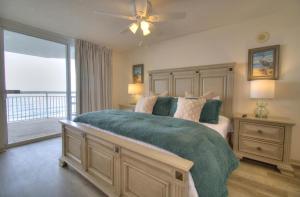a bedroom with a large bed with a ceiling fan at Crescent Shores South - 511 in Myrtle Beach +51 photos