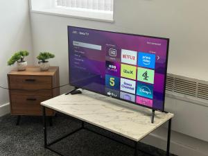 a large screen tv sitting on a table in an office at Pendle view- luxurious Studio in Brierfield