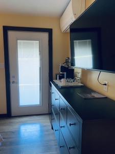 eine Küche mit einer blauen Theke und einer Tür mit einer Spüle in der Unterkunft Similkameen Valley Resort in Cawston