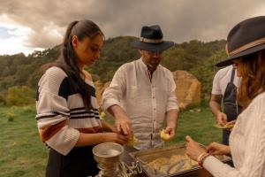 a group of people preparing food in a field at Hotel Casa Selvaggio in Ráquira