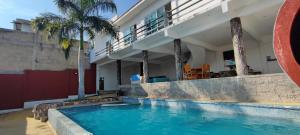 a swimming pool in front of a house at Blessed Rest Home Teques in Tequesquitengo