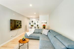 a living room with a blue couch and a table at Hot Tub and Game Room Luxe Cabin, Day Trip to Tahoe in Pollock Pines