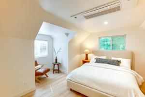 a white bedroom with a bed and a chair at Hot Tub and Game Room Luxe Cabin, Day Trip to Tahoe in Pollock Pines
