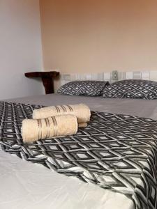 a bed with two towels on top of it at La Palma Hostel in Maragogi